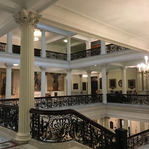 White columns with black detailed iron railing