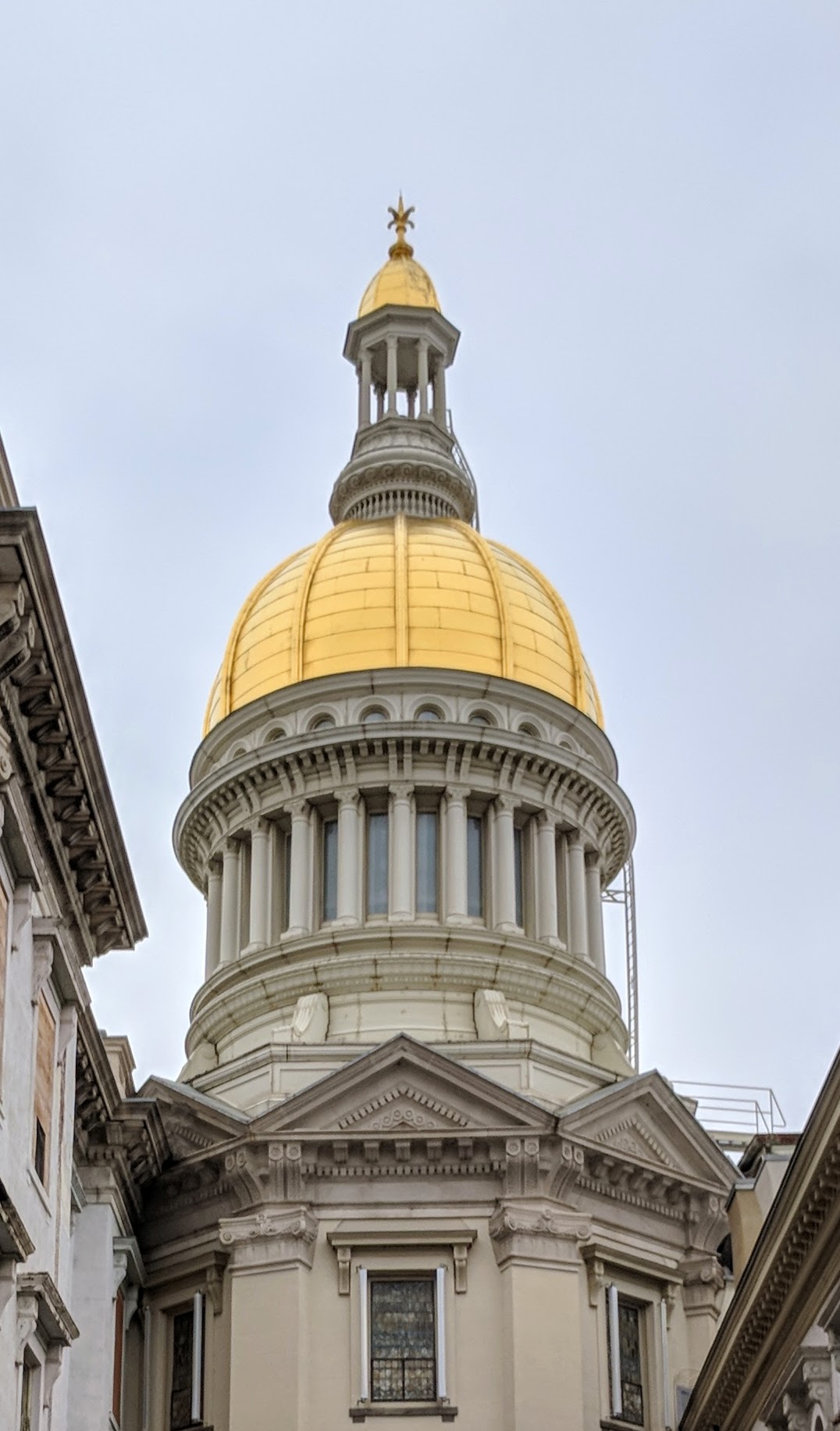 Gold dome on white stone statehouse