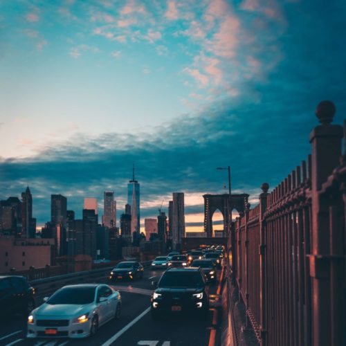 cars on Brooklyn Bridge at sunset