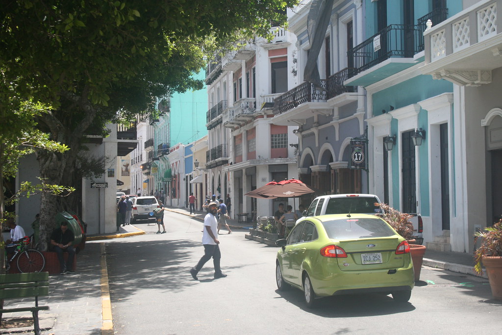 green car on street with colorful houses