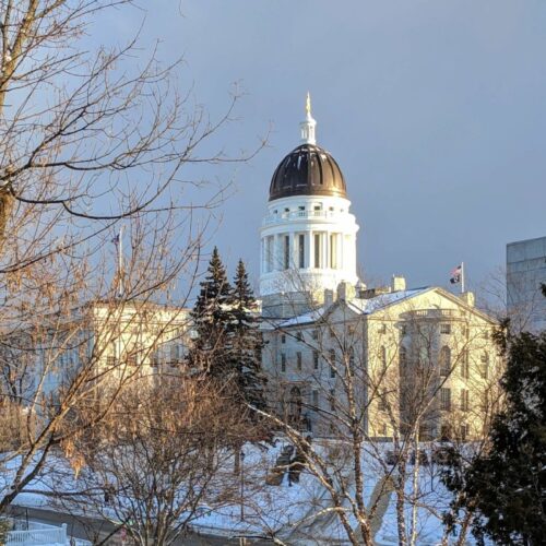 white capitol building with dome in winter