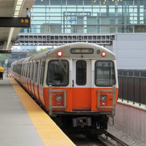 orange subway car at platform