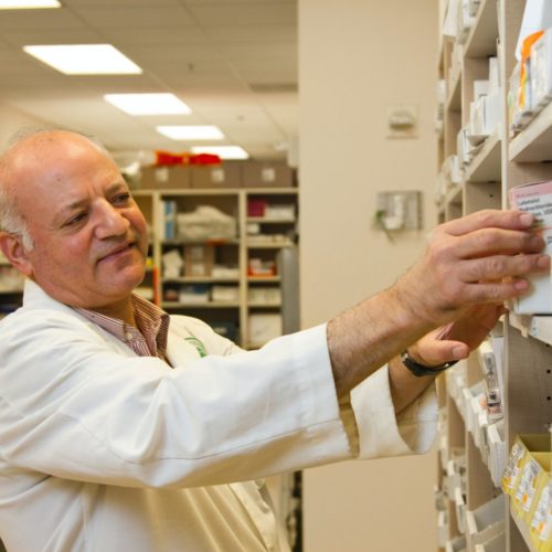 man in white lab coat in pharmacy